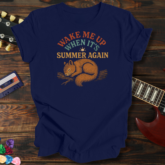 Navy blue t-shirt with a squirrel graphic and text on a wooden surface with a guitar and cassette tape.