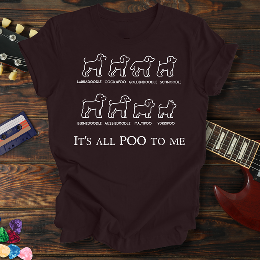 Maroon t-shirt with dog breed illustrations and text on a wooden surface with a guitar and cassette tape.