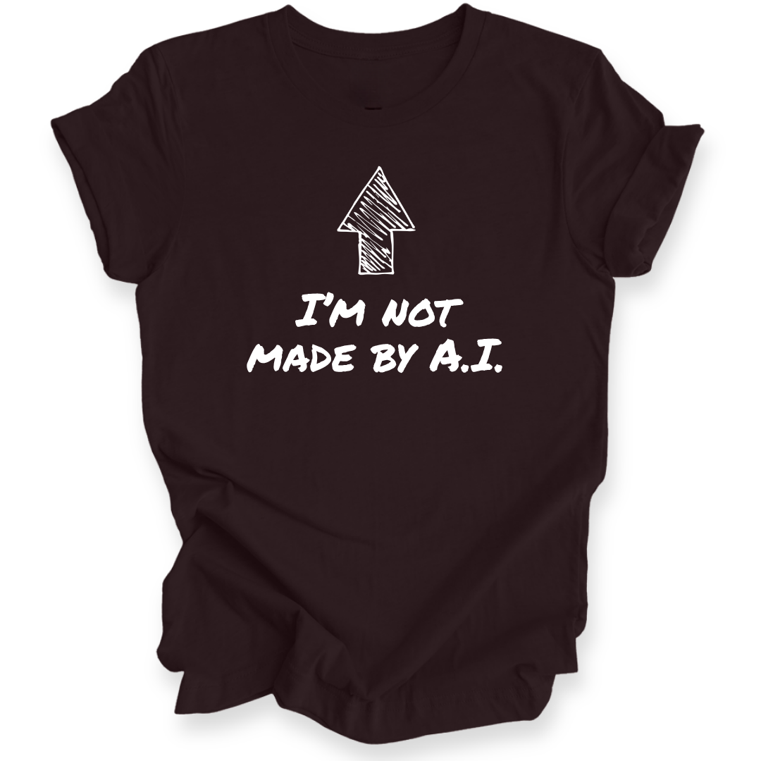 A maroon short-sleeve t-shirt with a black graphic print featuring an arrow and the text 'I'M NOT MADE BY A.I.