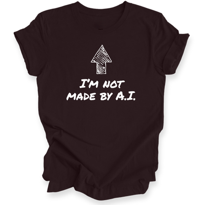A maroon short-sleeve t-shirt with a black graphic print featuring an arrow and the text 'I'M NOT MADE BY A.I.