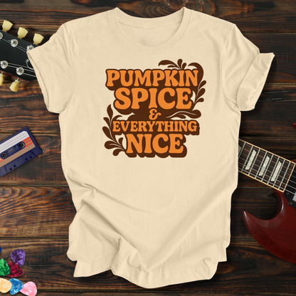 Beige t-shirt with 'Pumpkin Spice & Everything Nice' text on a wooden surface with a guitar and cassette tape.