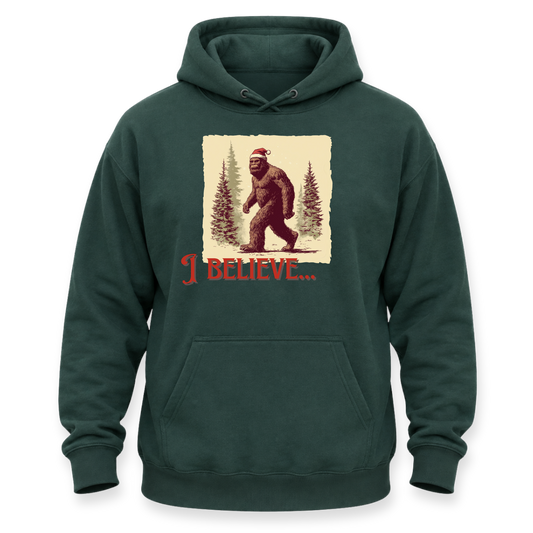 A dark green pullover hoodie with a front kangaroo pocket and a graphic print of Bigfoot wearing a Santa hat in a snowy forest, with the text 'I BELIEVE.