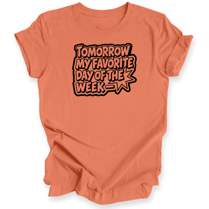 A coral orange short-sleeve t-shirt with a graphic text print reading 'TOMORROW MY FAVORITE DAY OF THE WEEK' in a comic-style outline font, shown on a plain white background.