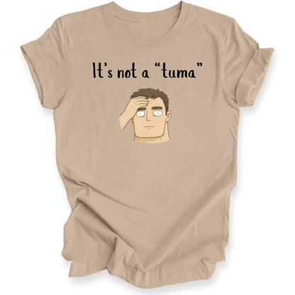 A tan short-sleeve t-shirt with a graphic print of a cartoon man's face and the text 'It's not a "tuma"' on the front, displayed against a plain white background.