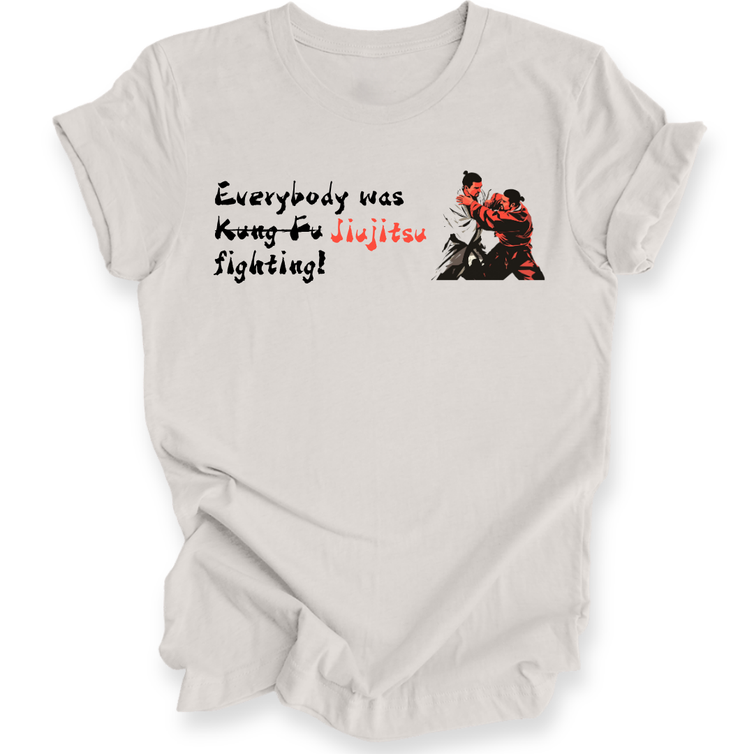 A light gray short-sleeve t-shirt with a graphic print on the front. The graphic features the text 'Everybody was Jiu-Jitsu fighting!' in black and red lettering, alongside an illustration of two martial artists in a grappling stance.
