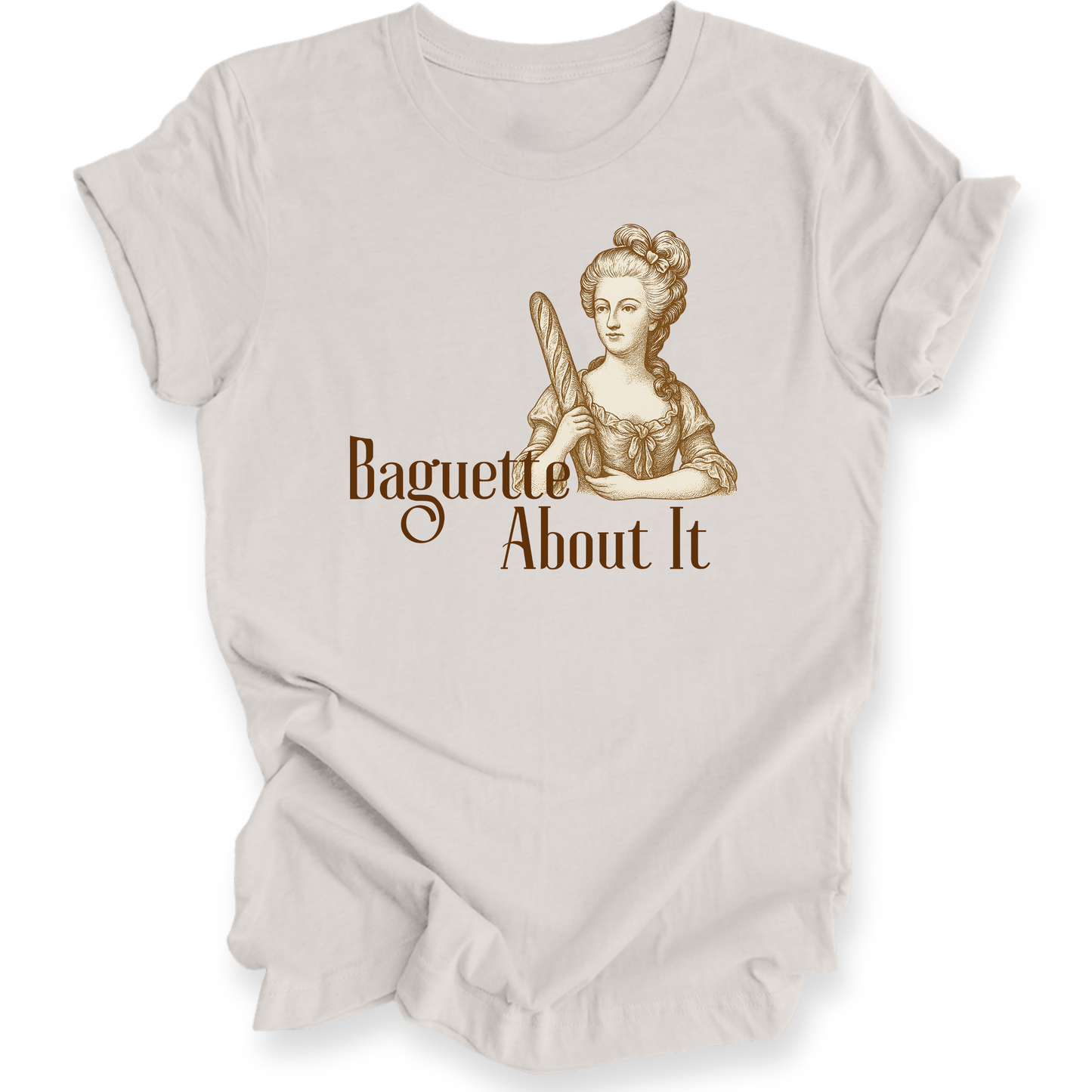Beige t-shirt with a graphic of a woman holding a baguette and text 'Baguette About It' on a white background