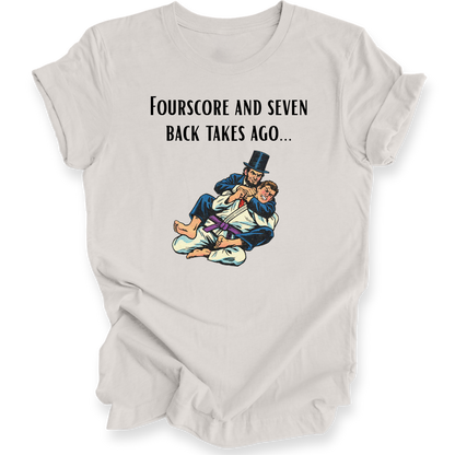 A light beige graphic t-shirt featuring the text 'FOURSSCORE AND SEVEN BACK TAKES AGO.