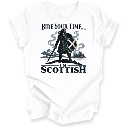 A white short-sleeve crewneck t-shirt with a graphic print of a Scottish warrior in a tartan kilt holding a sword and shield, with the text 'BIDE YOUR TIME.