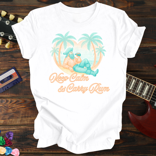White t-shirt with a tropical design and text on a wooden surface with a guitar and cassette tape.