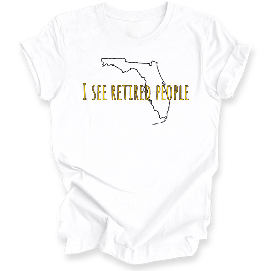 A white short-sleeve crewneck t-shirt with a graphic of the state outline of Florida in black, with the text 'I SEE RETIRED PEOPLE' written across it in a textured gold font.